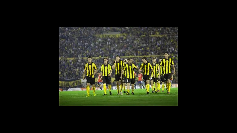 Cầu thủ Racing Montevideo và Penarol tranh chấp bóng trên sân
